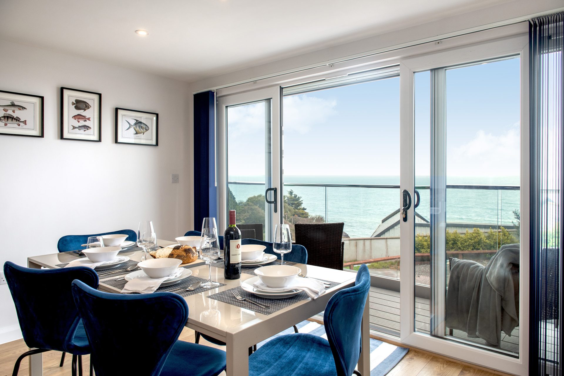 Dining area view with table chairs and large patio doors looking out to sea